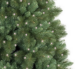 Close-up of a green artificial Christmas tree with lights on a white background