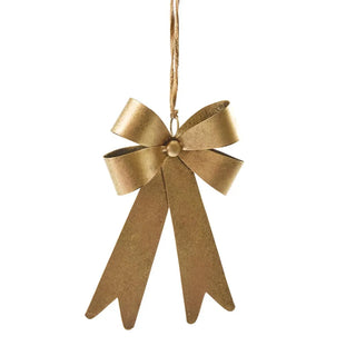 Gold bow ornament hanging on a white background
