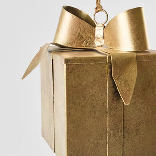 Gold gift box with a gold bow on a light gray background