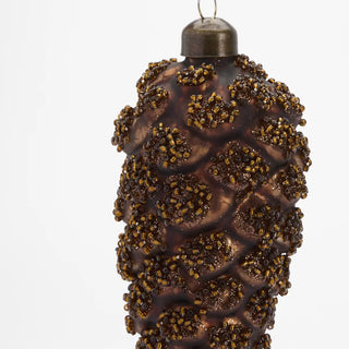 Decorative pine cone ornament with brown glittery finish on a white background