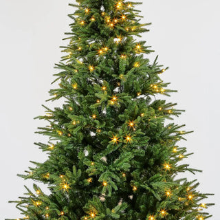 Decorated Christmas tree with lights on a plain background
