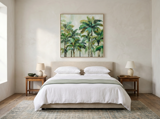 Cairns Nat framed canvas artwork above a linen bedhead in a calm master bedroom — crisp white linen, soft sage throw, vintage timber bedside tables