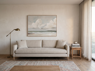 Hillston Ash coastal canvas artwork hanging above an oatmeal linen sofa in an elegant Sydney living room — slim natural-tone frame, brass floor lamp, vintage timber side table