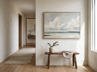 Hillston Ash framed coastal canvas artwork above a vintage timber bench in a calm Australian hallway — eucalyptus stems in a stoneware vase, oak floors, natural light