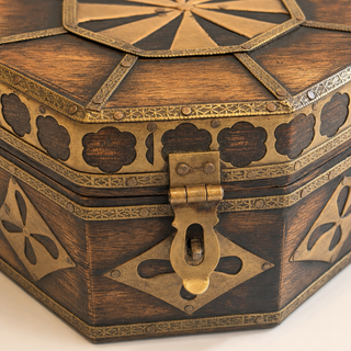 Close-up of the ornate brass clasp and floral medallion inlay on the octagonal wooden box
